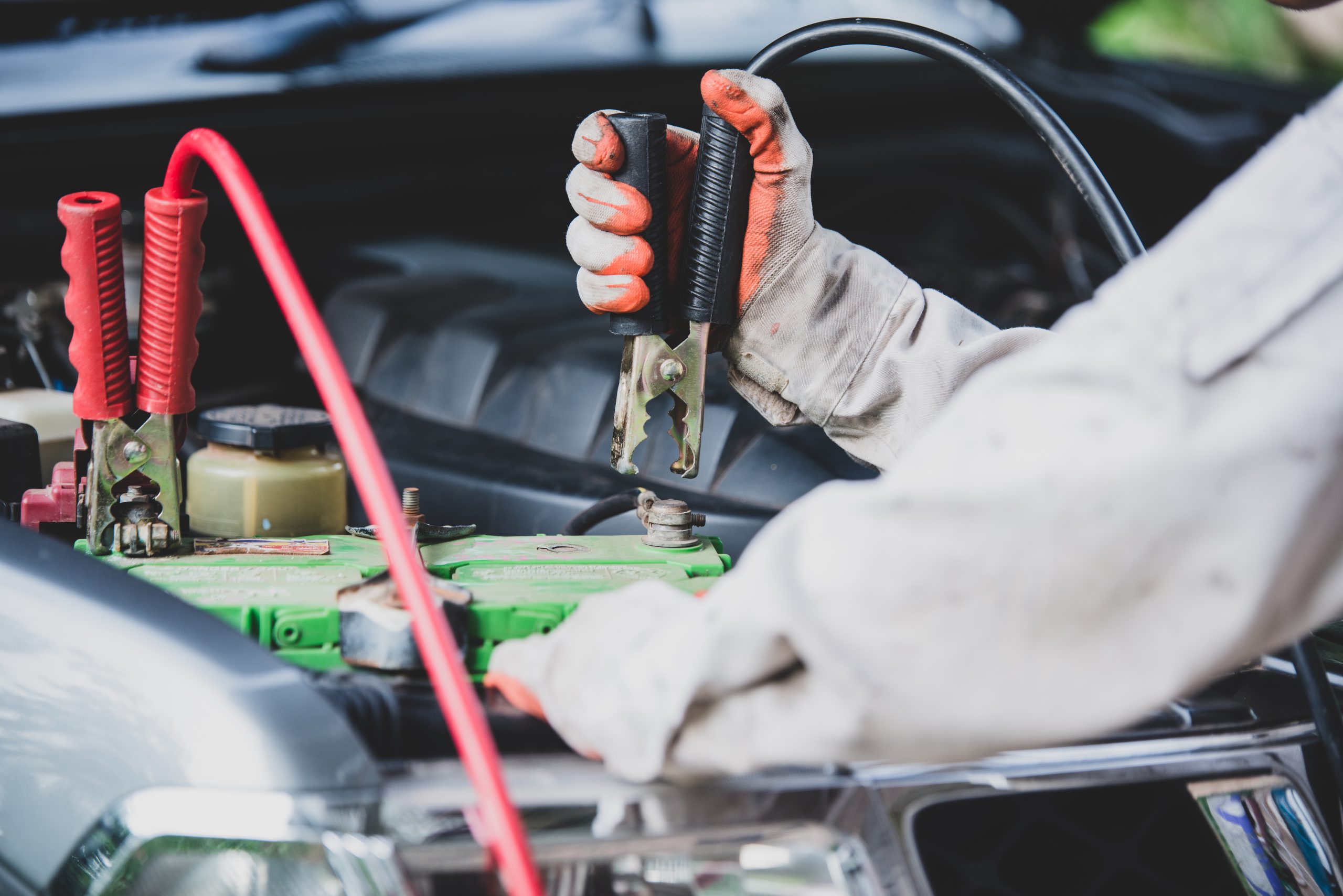Car repairman wearing a white uniform standing and holding a wre